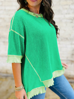 Bright green ribbed t-shirt with contrast stitching and asymmetrical hem.