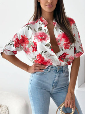 Floral print blouse with mandarin collar and button front, short sleeves, in white with red and pink flowers.
