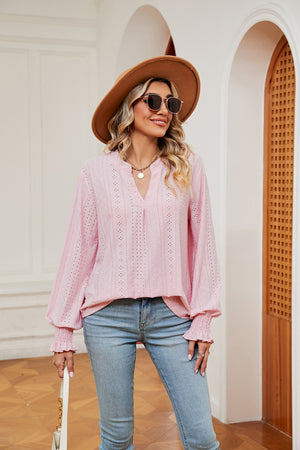 Blush pink eyelet detail poet sleeve blouse with v-neck and ruffled cuffs.