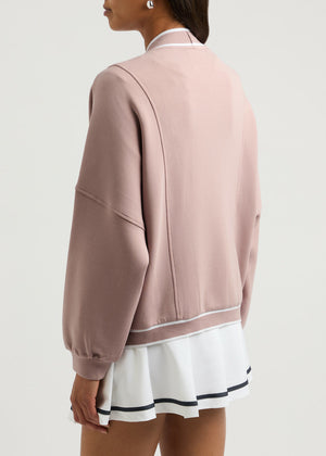 Dusty pink cocoon cardigan with varsity trim and button detail.