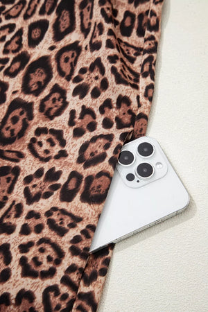 Leopard print cotton mini dress with a pocket shown holding a smartphone.