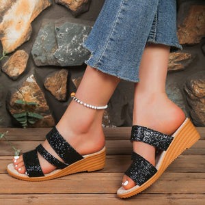 Black sequined wedge sandals with double straps and cork wedge heel.