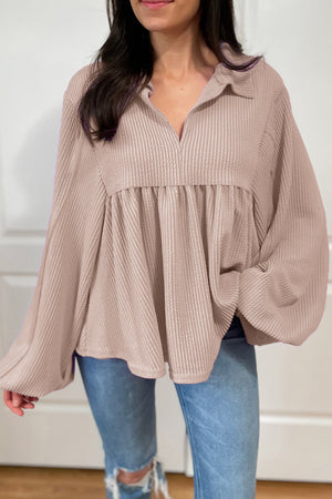 Beige textured blouse with gathered yoke, collar, and balloon sleeves.