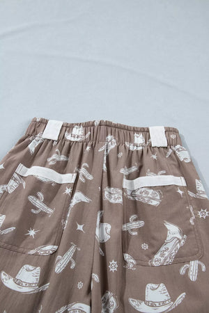Brown cotton joggers with white western print featuring cactuses and cowboy hats.