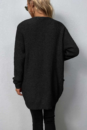 Black waffle knit longline cardigan with pockets and ribbed cuffs.