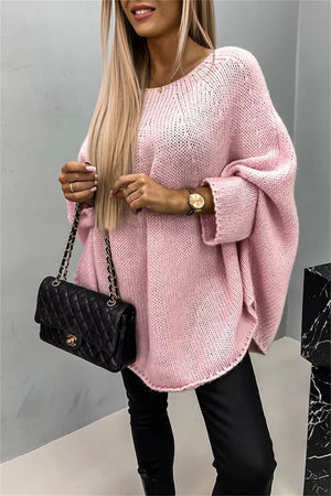 Relaxed blush pink knit sweater with cape sleeves and a round neckline.