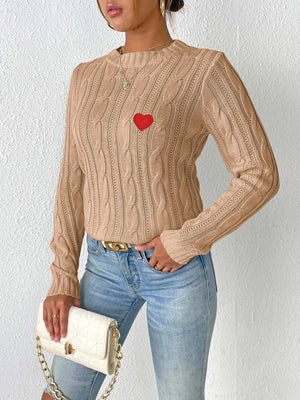 Camel cable knit sweater with embroidered red heart detail.