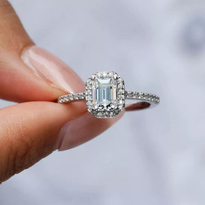 Radiant Moissanite engagement ring in silver with emerald cut center stone and halo.