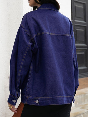 Dark oversized denim trucker jacket with contrast stitching and buttoned cuffs.