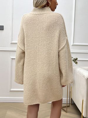 Beige knit mini dress with voluminous sleeves and a high neckline, shown from the back.