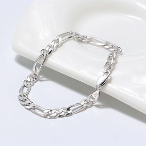 Sterling silver Figaro chain bracelet with alternating links and a lobster clasp.
