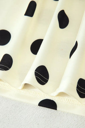 Cream polyester t-shirt with black polka dots and a high neckline detail.