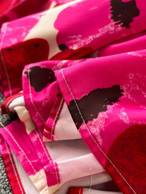 Vibrant floral tiered cami dress with pink, red, and black abstract floral print.