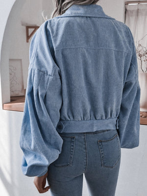 Blue corduroy cropped jacket with balloon sleeves and button detail.