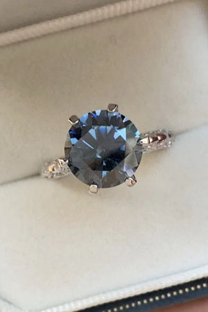 Midnight blue solitaire engagement ring with diamond-accented band.
