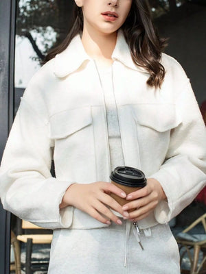 White cropped zip-up jacket with collar and two chest pockets.