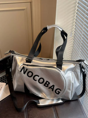 Silver leather duffel bag with black straps and "NOCOBAG" text detail