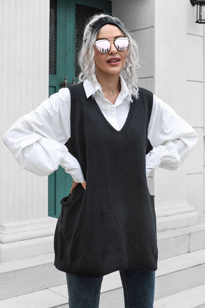 Black oversized knit vest with V-neck and front pockets, styled over a white shirt.