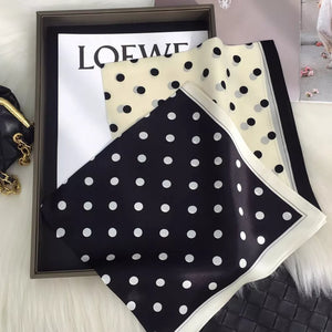 Sophisticated polka dot silk scarf in black and cream white with a bordered edge.