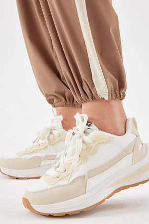 Camel relaxed trousers with cream side stripe detail and elasticated cuffs.