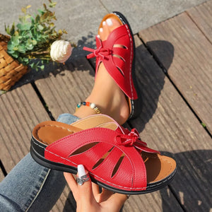 Red criss-cross wedge sandals with bow detail and cut-out design.