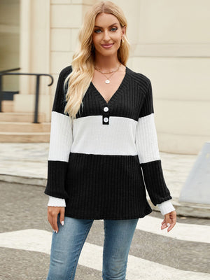 Ribbed Henley sweater with black and white colorblock, V-neck, and button detail.