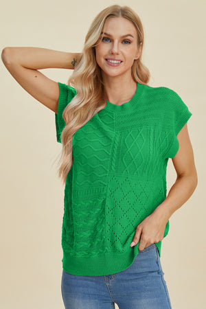 Green knit patchwork top with cable and diamond stitch details, short sleeves.