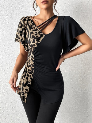 Asymmetric black top with leopard print panel, cutout neckline, and ruched detail.