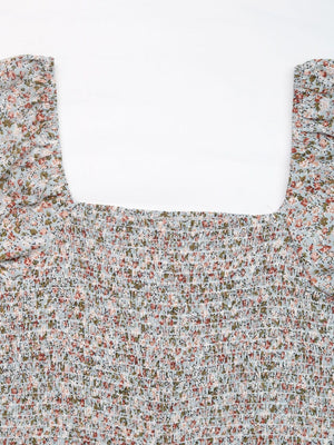 Light blue floral smocked bodice jumpsuit with square neckline and puff sleeves.