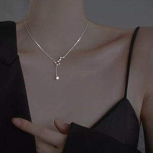Sterling silver necklace with constellation design and dangling crystal pendant.