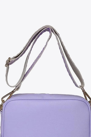Lavender textured crossbody bag with a woven strap and gold hardware detail.