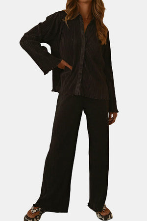 Black pleated shirt and wide-leg trouser set with satin collar detail.