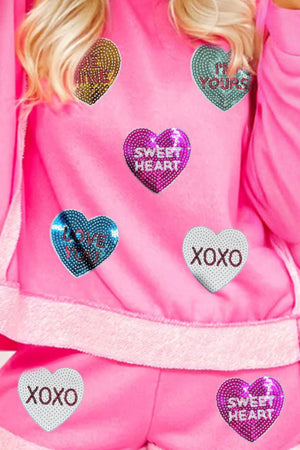 Pink loungewear set with sequin heart appliques that say Sweetheart, Love You, I'm Yours, and XOXO.