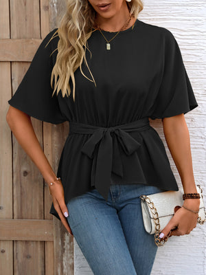 Black blouse with short dolman sleeves, cinched tie-waist, and asymmetrical peplum hem.