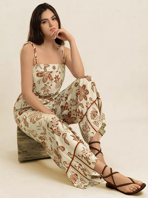 Tropical tie strap wide-leg romper in cream with brown floral print, square neckline.