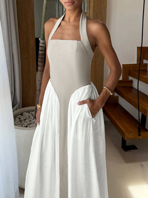 Halter neck two-tone maxi dress with beige bodice and white skirt, featuring pockets.