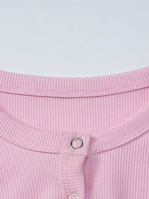 Dusty pink ribbed long sleeve top with button detail at the neckline.