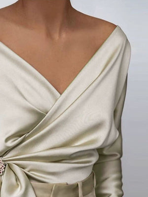 Cream satin blouse with draped detail and brooch accent