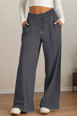 Seamed palazzo lounge trousers in dark gray with drawstring waist and pockets.