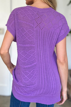 Purple knit patchwork top with cable and lace details, short sleeves.