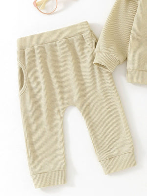 Toddler waffle knit top and pants set in apricot with pocket detail.
