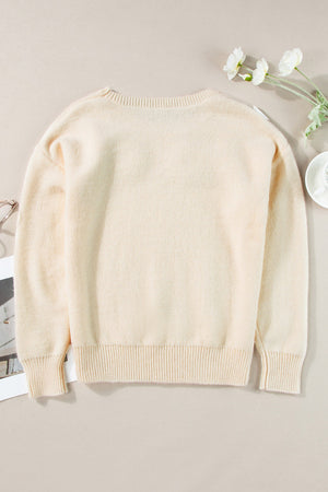 Tan knit sweater with embroidered floral appliqué, crew neck, long sleeves, ribbed cuffs and hem.