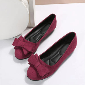 Burgundy suede pointed-toe flats with bow embellishment