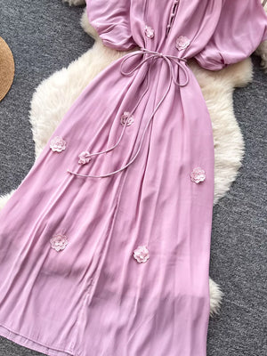 Purple floral maxi dress with puff sleeves, tie waist, and button front.