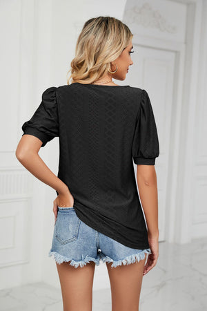 Black eyelet puff sleeve scoop neck blouse with textured fabric.