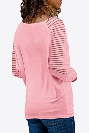 Carnation pink long sleeve top with sheer striped raglan sleeves and V-neck.