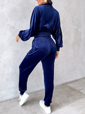 Navy velvet crop tracksuit with elastic waist and zipper detail.