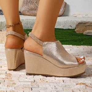 Gold wedge sandals with elastic straps and open toe, featuring a platform sole.