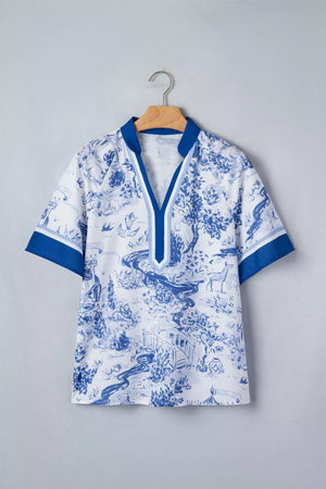 White polyester shirt with blue toile print, V-neck, short sleeves, and contrast trim.