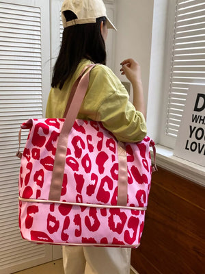 Vibrant pink travel bag with bold red leopard print and dual straps.